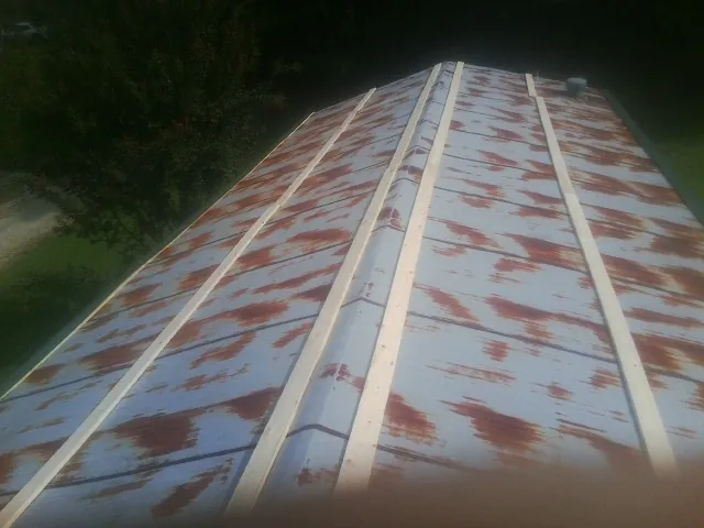 Rusted metal roof panels with new wood purlins before replacement — Storm Damage Roof Repair in Plano by Roofing Brothers