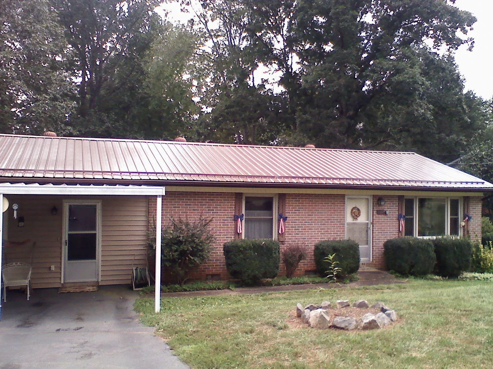 Bronze metal roof and carport on a brick ranch home — Roof Repair work by our crew in Plano