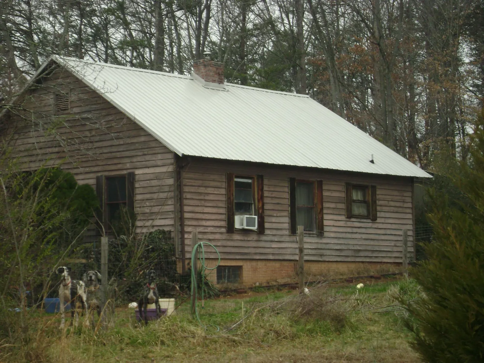 White metal roof on an old wood sided farmhouse, from a Metal Roof Installation job in Plano